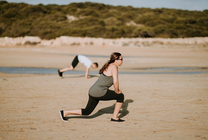 CBI Mujer haciendo ejercicio en la playa Columna Unsplash