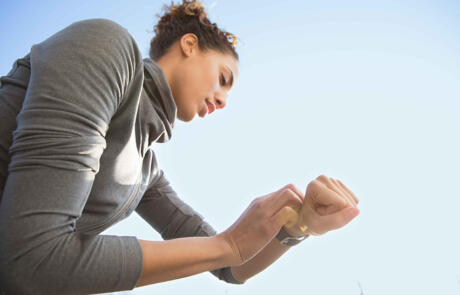 Tecnología MX20 LIFESTYLE mujer corriendo al aire libre comprobando la columna del reloj