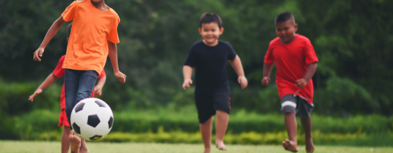 Niños jugando al fútbol 910x690